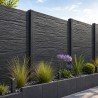 Poteau de finition en béton anthracite avec clôture béton imitation pierre dans un jardin moderne.
