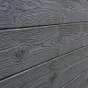 Gros plan sur le relief et la texture d'une clôture béton imitation lames bois.